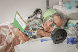Пациент на хосписа чете книга в леглото